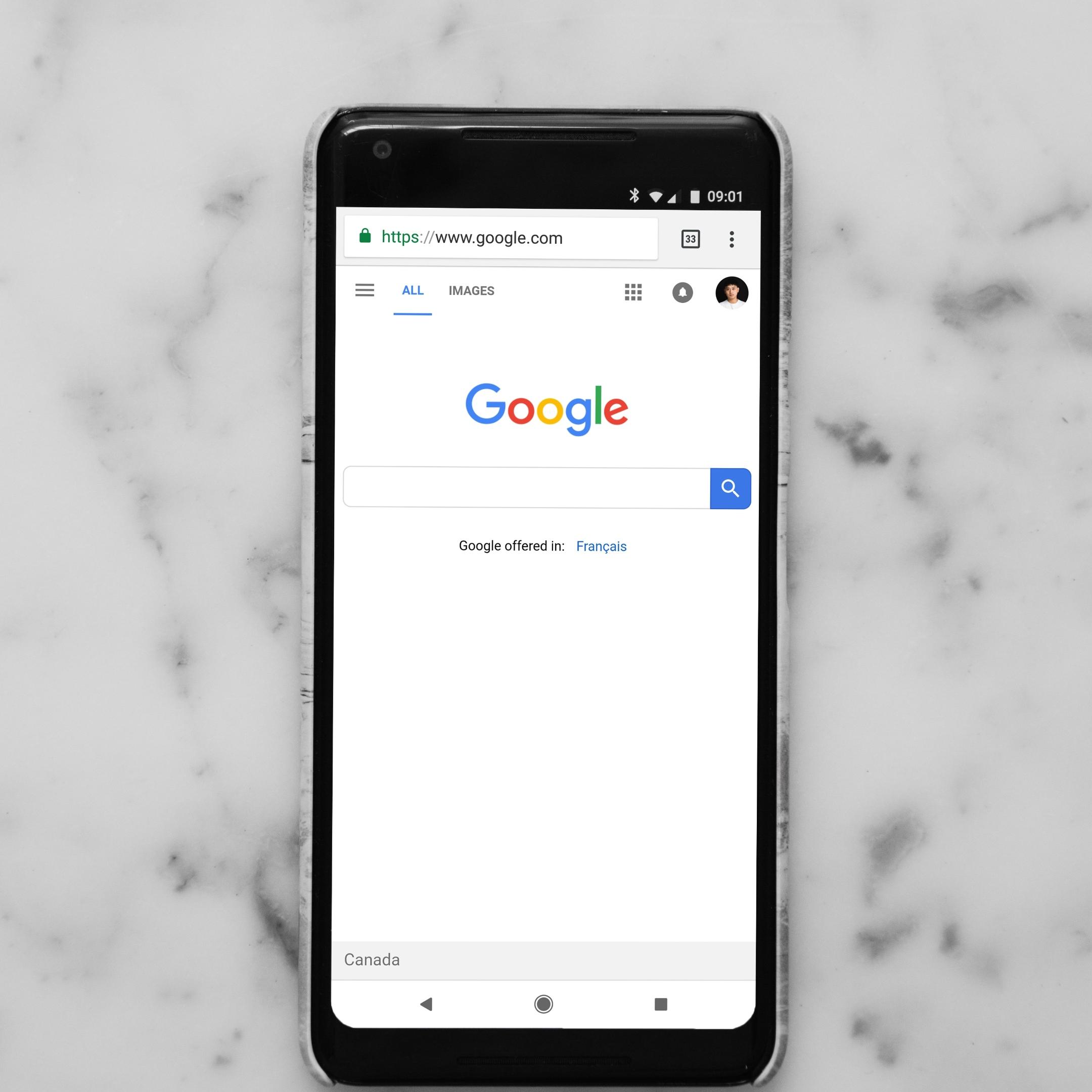 Smartphone mit geöffneter Startseite der Google-Suche