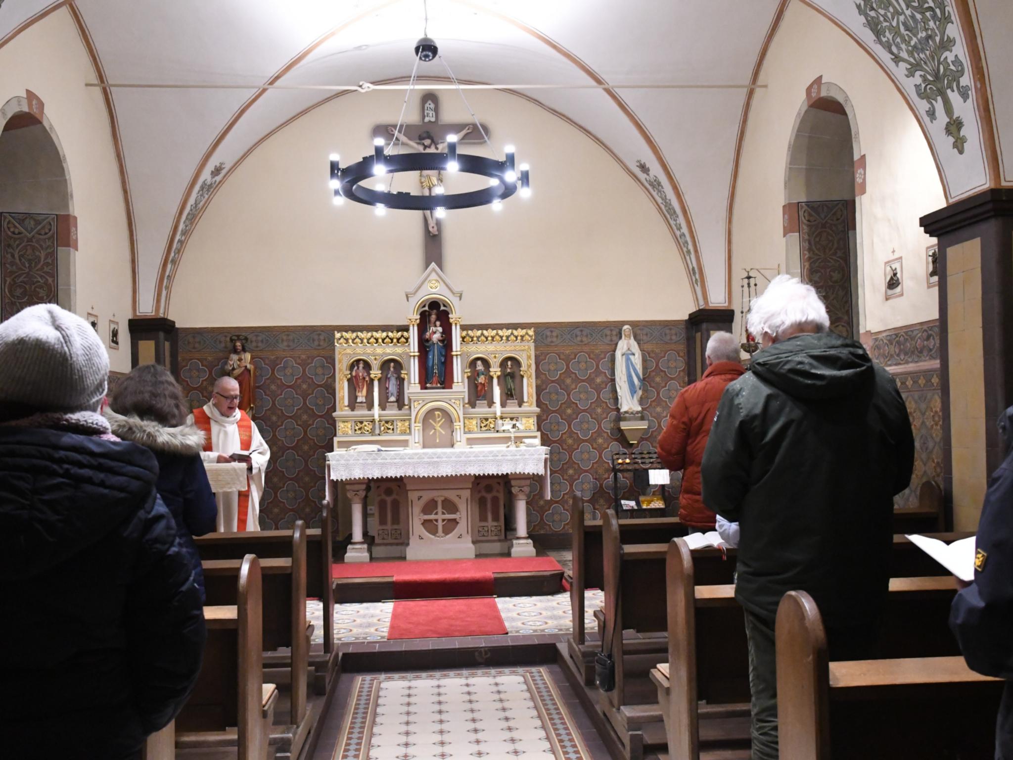 Auch im Winter gerne Gottesdienst feiern: Die Heizung unter anderem in den Lampen der Kapelle in Bitburg-Stahl wärmt bei ungemütlichen Außentemperaturen die Gemeinde auf.