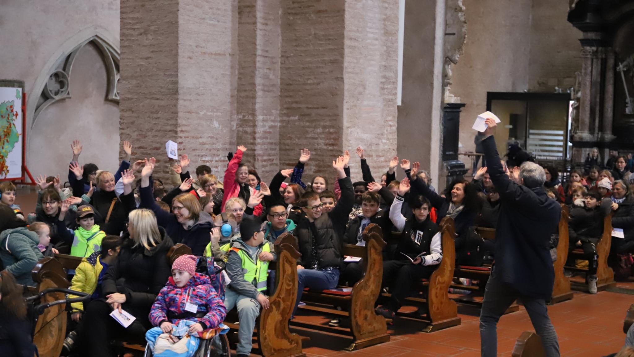 Teamleiter Patrick Wilhelmy begrüßt die Kinder beim Begegnungstag der Förderschulen im Dom