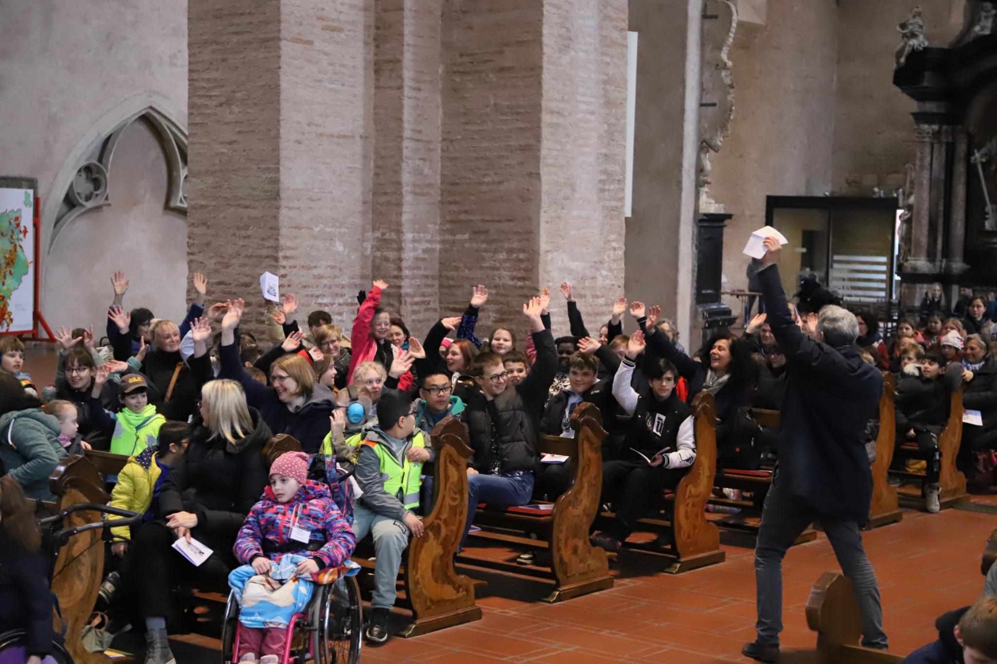 Teamleiter Patrick Wilhelmy begrüßt die Kinder beim Begegnungstag der Förderschulen im Dom