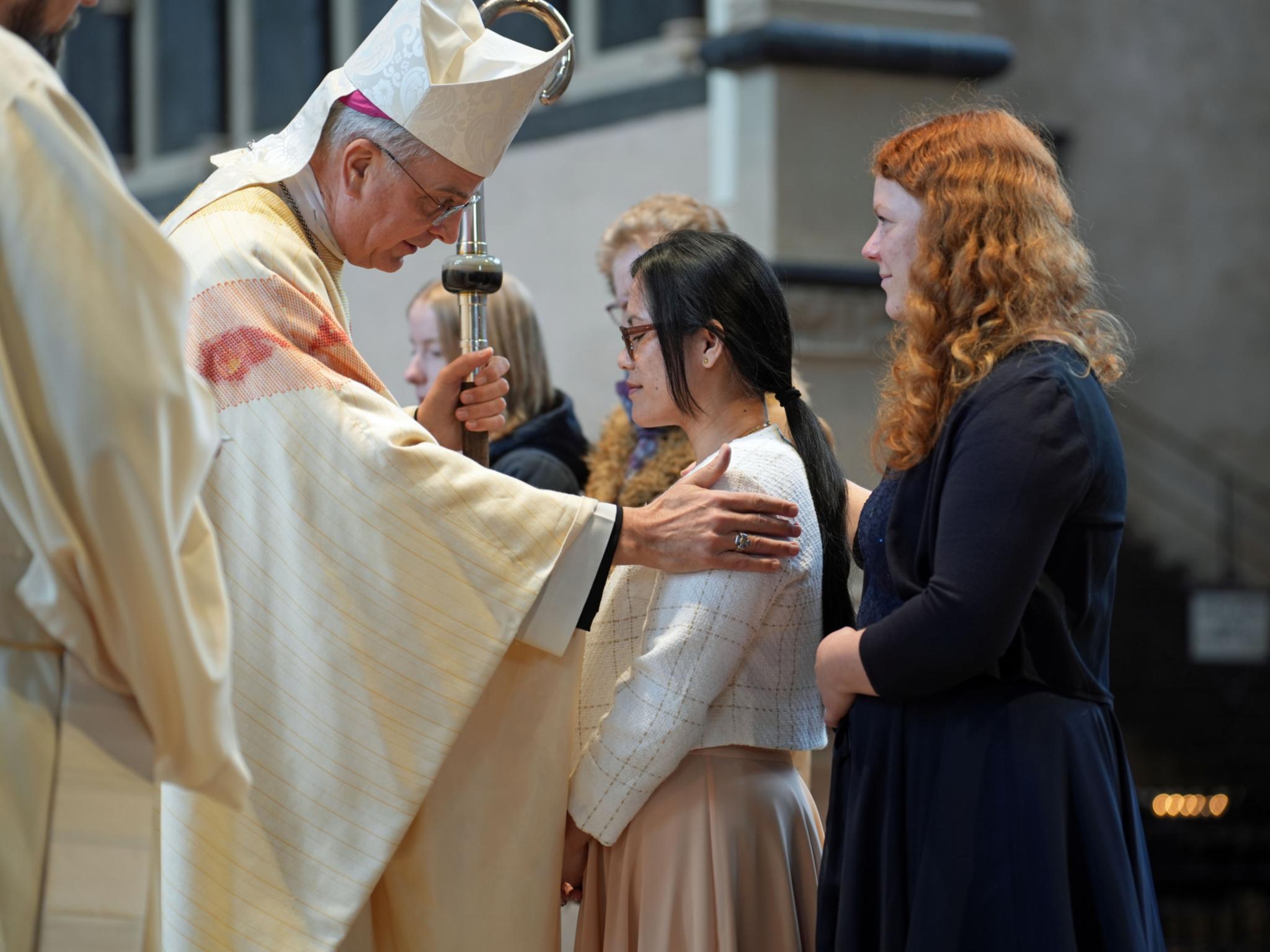 Weihbischof Jörg Michael Peters spendet einer jungen Frau das Sakrament der Firmung