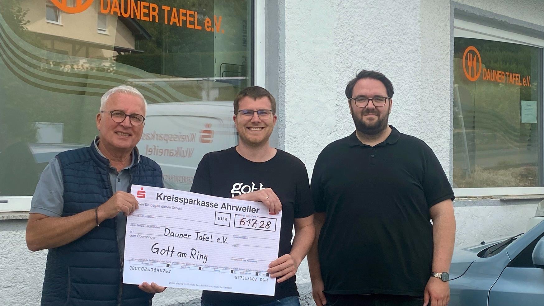 Christian Bauer (links) und Jörg Freitag (rechts) freuen sich über die Spende, die Philipp Hein vom Gott-am-Ring-Zelt der Dauner Tafel überreicht.