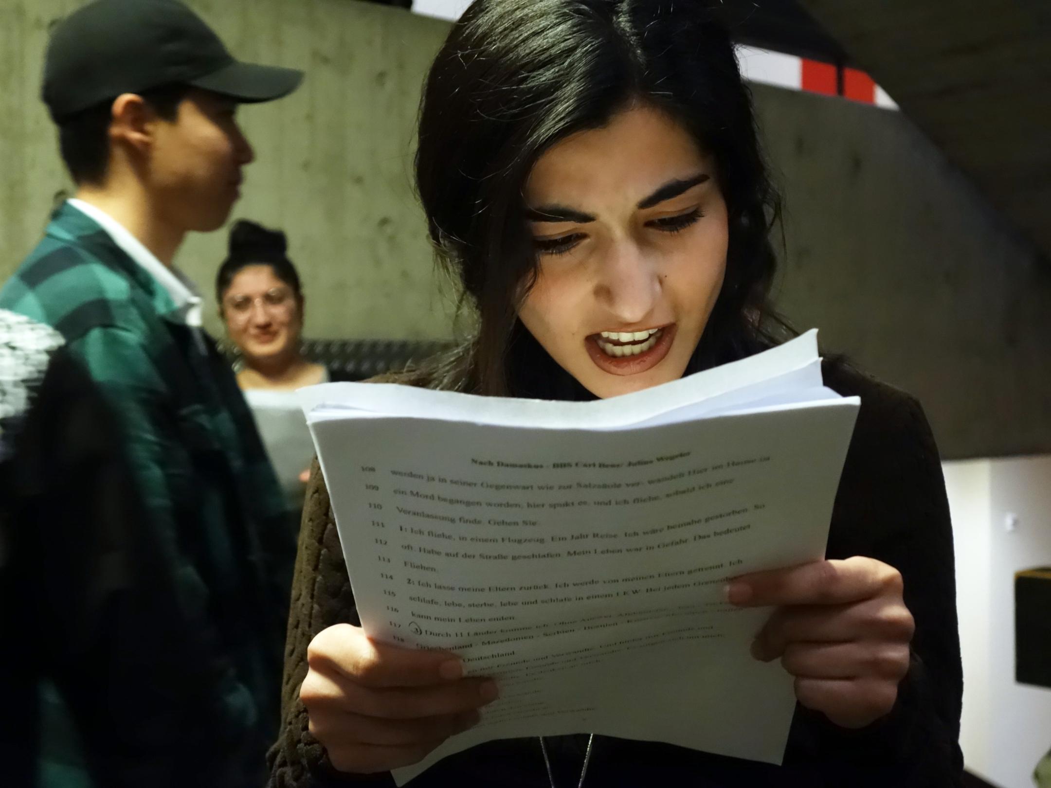 Eine junge Frau liest von einem Blatt ab.