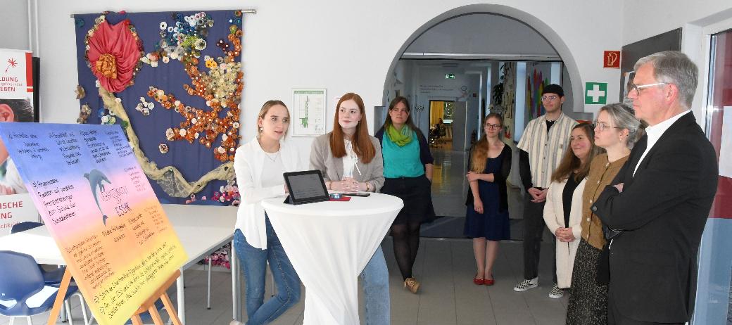 Vivien Schneider und Anna Walle (v. l.) stellen Generalvikar von Plettenberg den Verhaltenskodex der Schule vor.