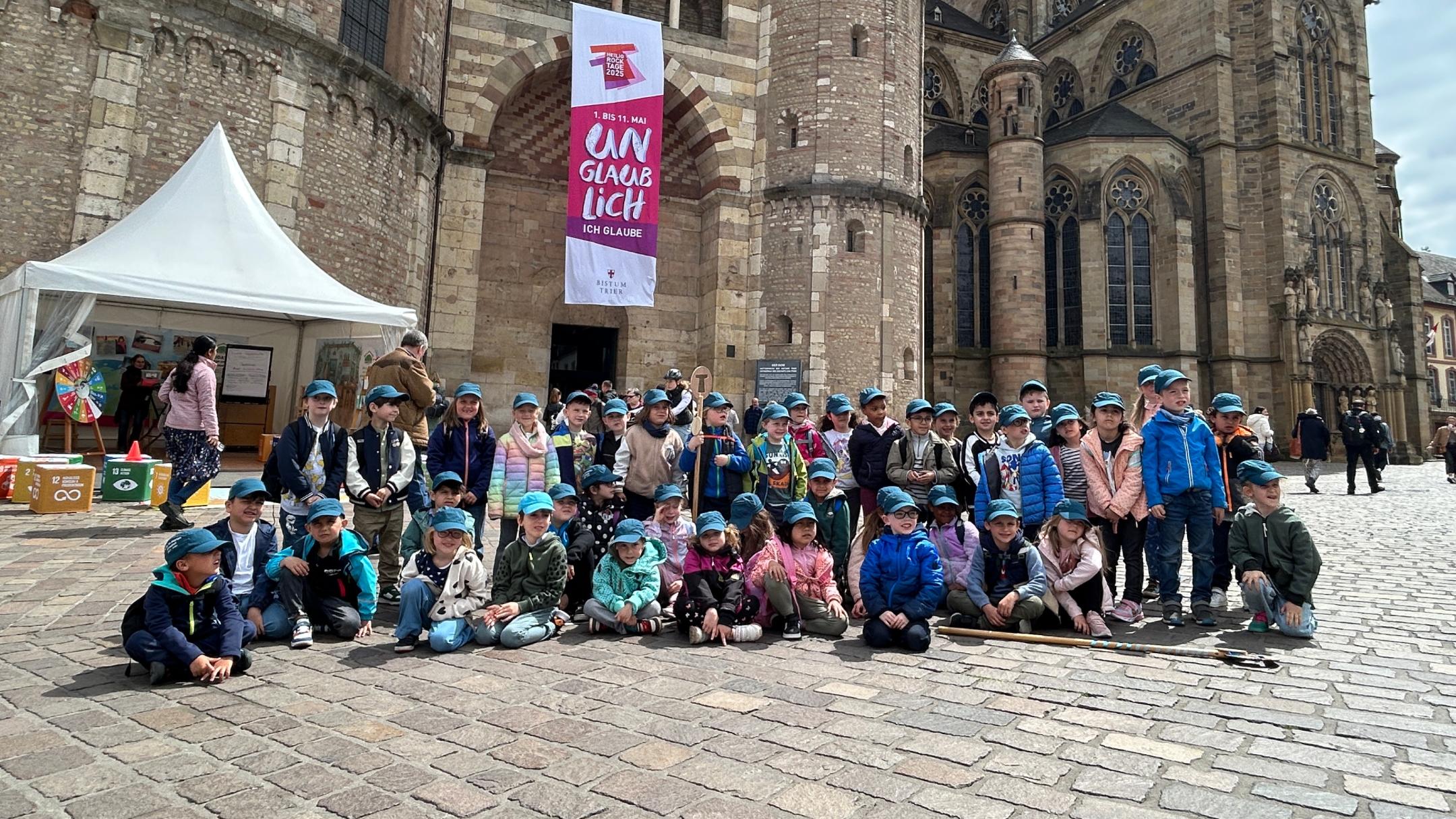 Eine Gruppe Kinder posiert für ein Foto vor dem Trierer Dom