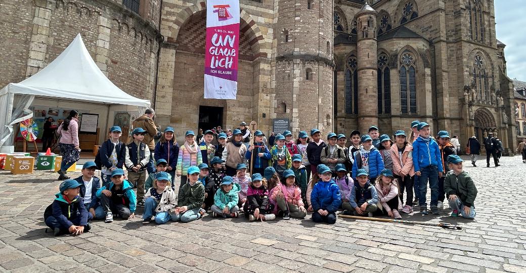 Eine Gruppe Kinder posiert für ein Foto vor dem Trierer Dom