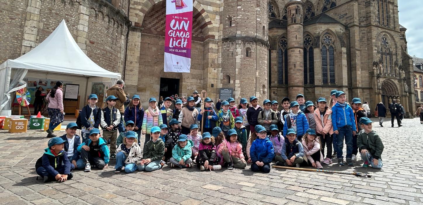 Eine Gruppe Kinder posiert für ein Foto vor dem Trierer Dom