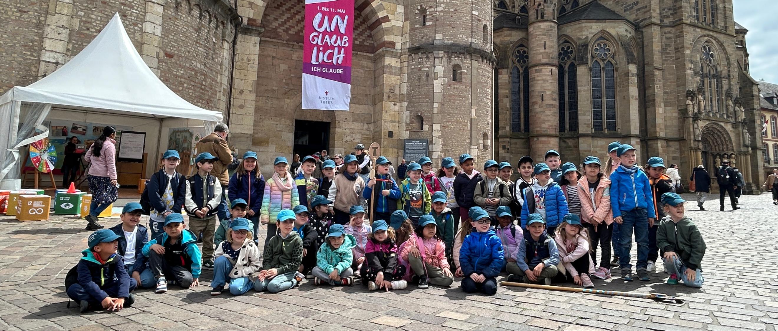 Eine Gruppe Kinder posiert für ein Foto vor dem Trierer Dom