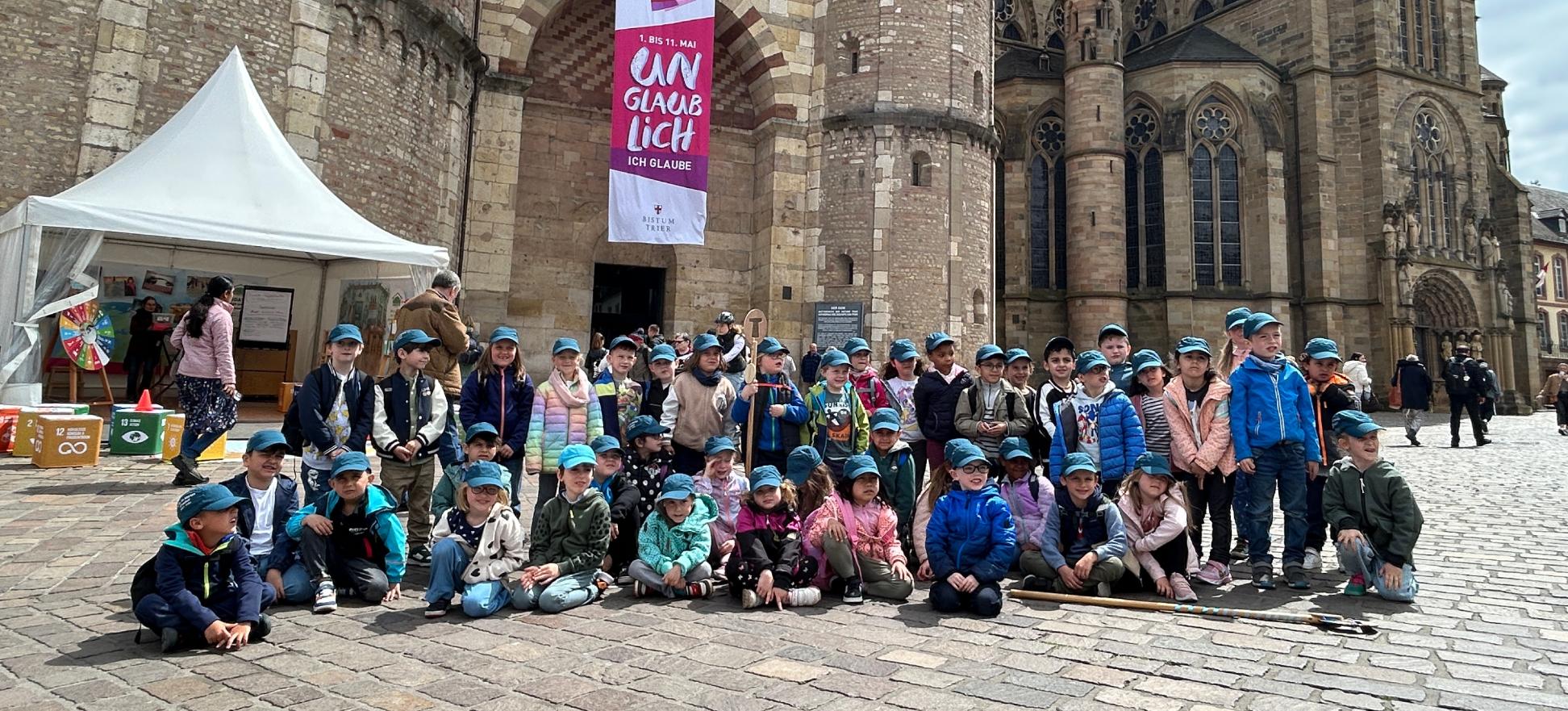 Eine Gruppe Kinder posiert für ein Foto vor dem Trierer Dom