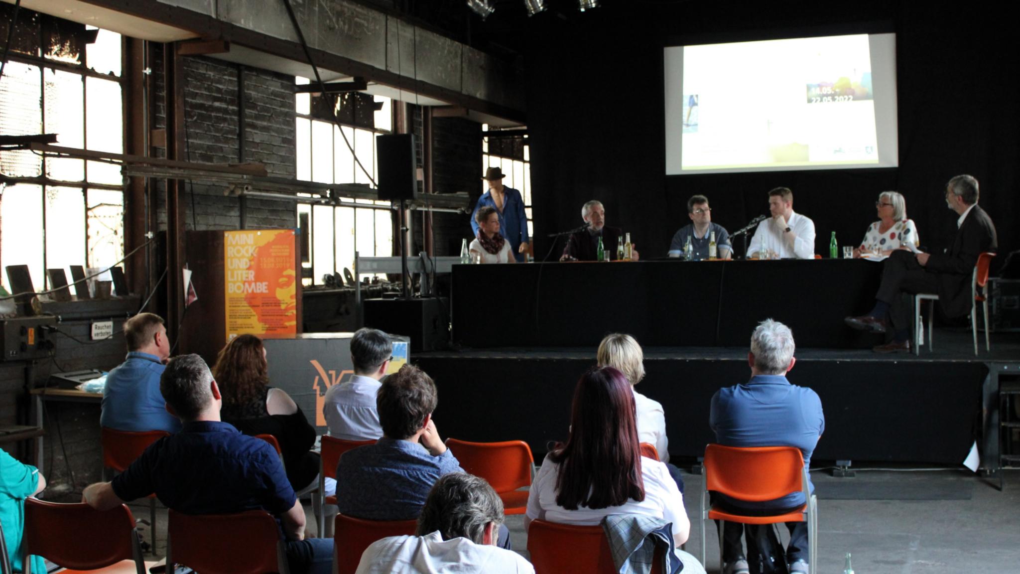 Rustikale Atmosphäre in der gut besuchten Dudweiler Kulturfabrik. Auf dem Podium (v.l.) Ulrike Laux, Dr. Andreas Zimmer, Ralf-Peter Fritz, Tobias Raab, Ulrike Zuda-Tietjen und Moderator Wolfgang Drießen, Foto: evks/Eulenstein