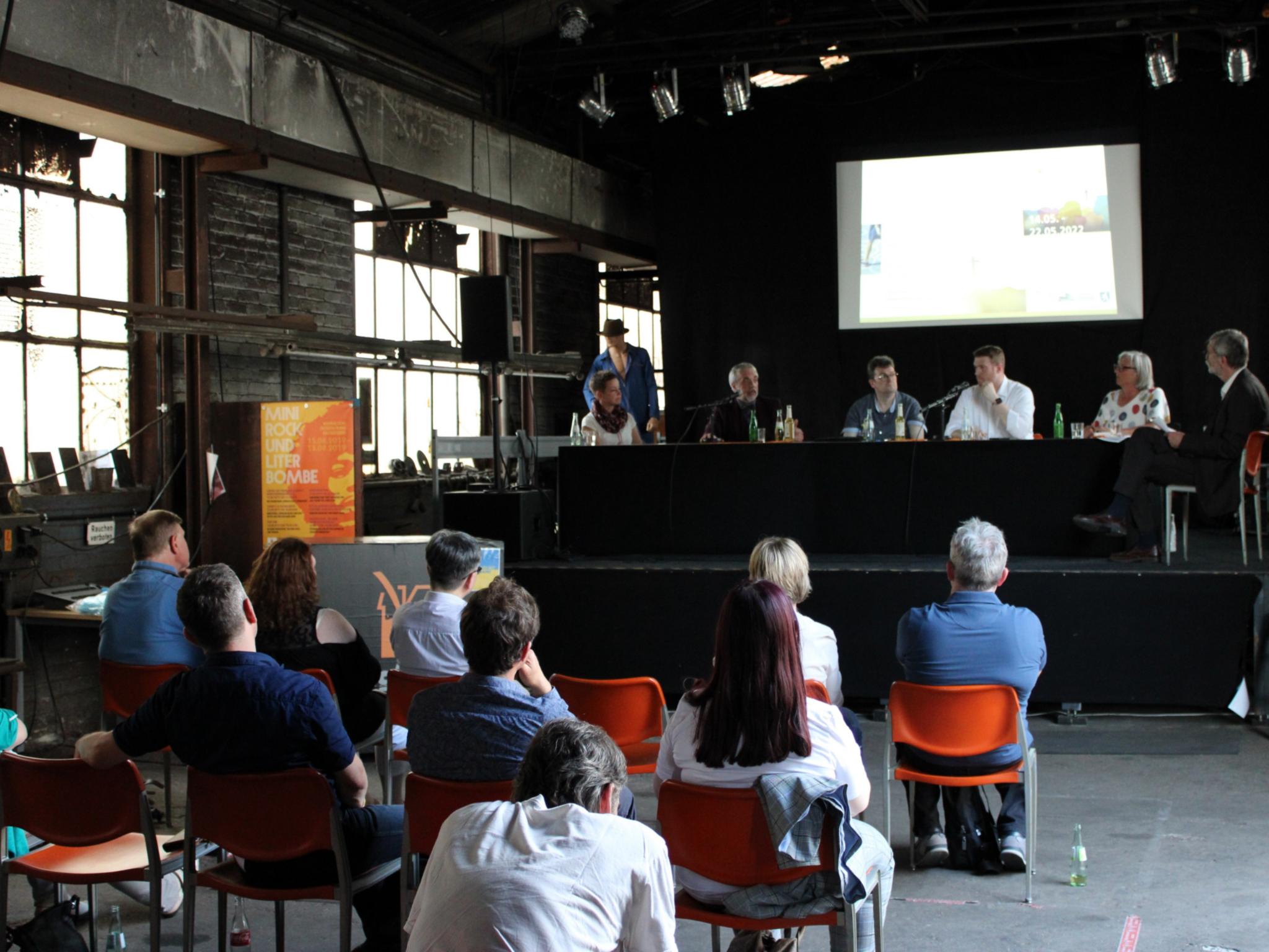 Rustikale Atmosphäre in der gut besuchten Dudweiler Kulturfabrik. Auf dem Podium (v.l.) Ulrike Laux, Dr. Andreas Zimmer, Ralf-Peter Fritz, Tobias Raab, Ulrike Zuda-Tietjen und Moderator Wolfgang Drießen, Foto: evks/Eulenstein