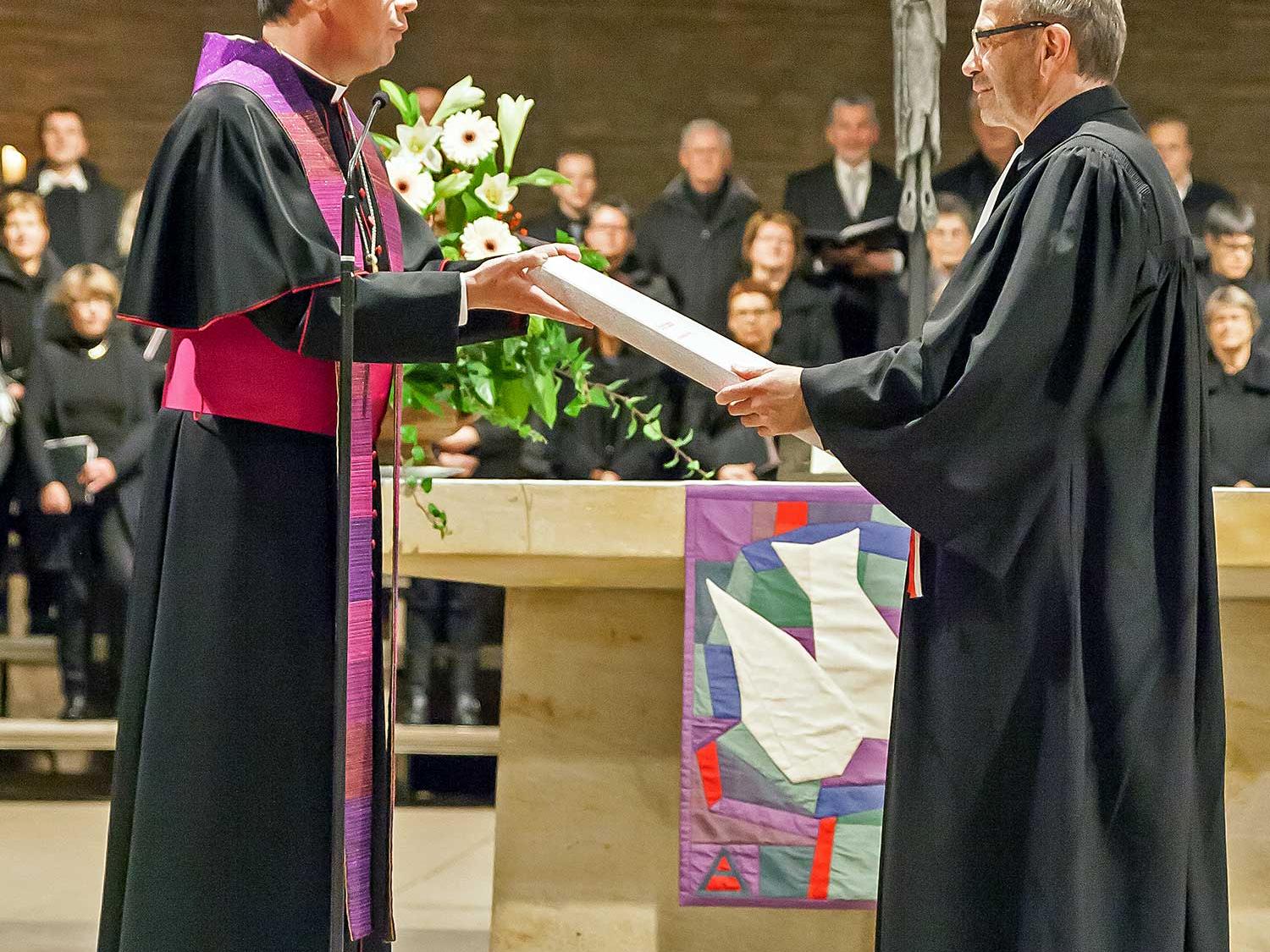 Bischof Ackermann übergibt das Evangeliar an Präses Rekowski