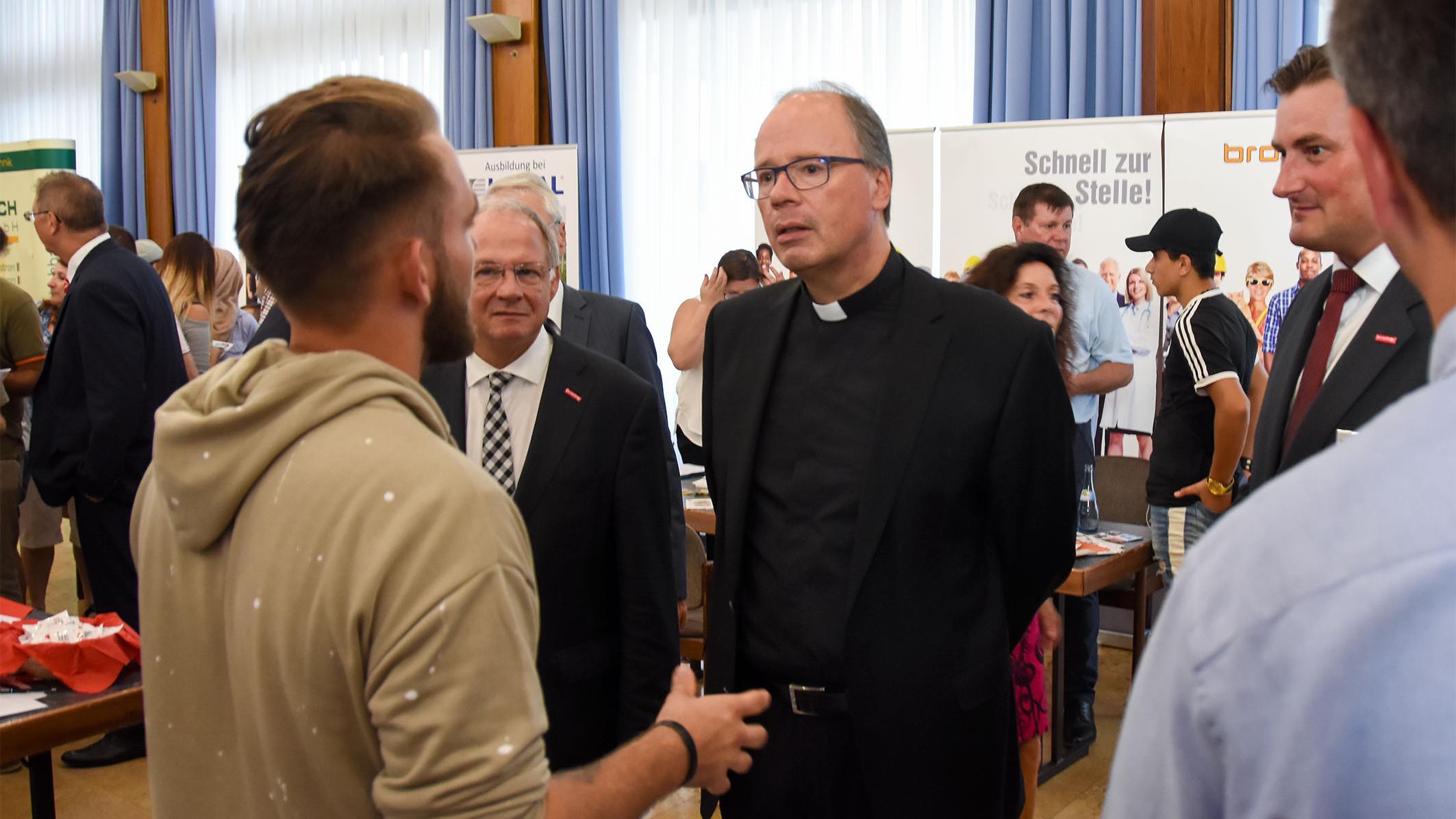 Bischof Ackermann in Begleitung vom Präsidenten der Handwerkskammer Bernd Wegner MdL im Gespräch mit einem der Aussteller auf der Jobbörse.