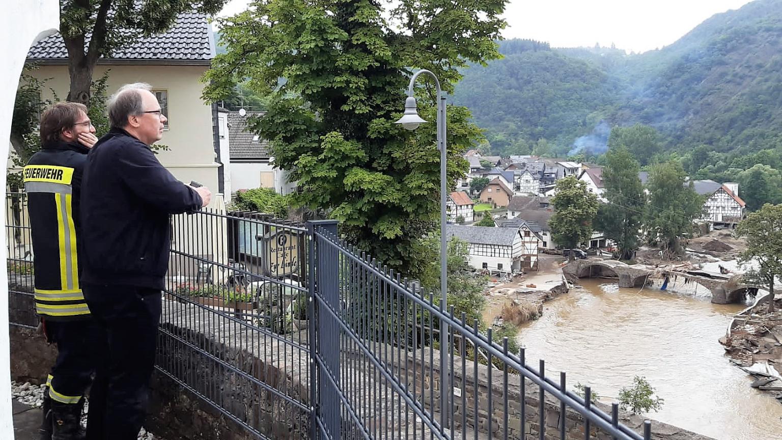 Bischof Ackermann blickt mit einem Mitglied der Feuerwehr auf den Ort Schuld, um sich ein Bild vom Ausmaß der Zerstörung zu machen. (Foto: Bistum Trier/M. Lutgen)