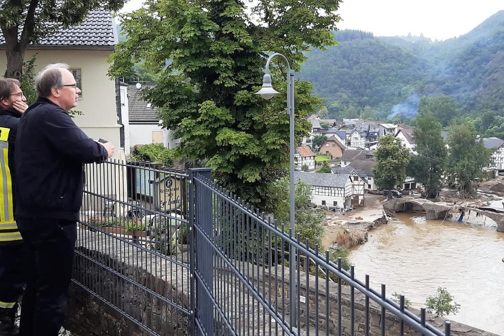 Bischof Ackermann blickt mit einem Mitglied der Feuerwehr auf den Ort Schuld, um sich ein Bild vom Ausmaß der Zerstörung zu machen. (Foto: Bistum Trier/M. Lutgen)