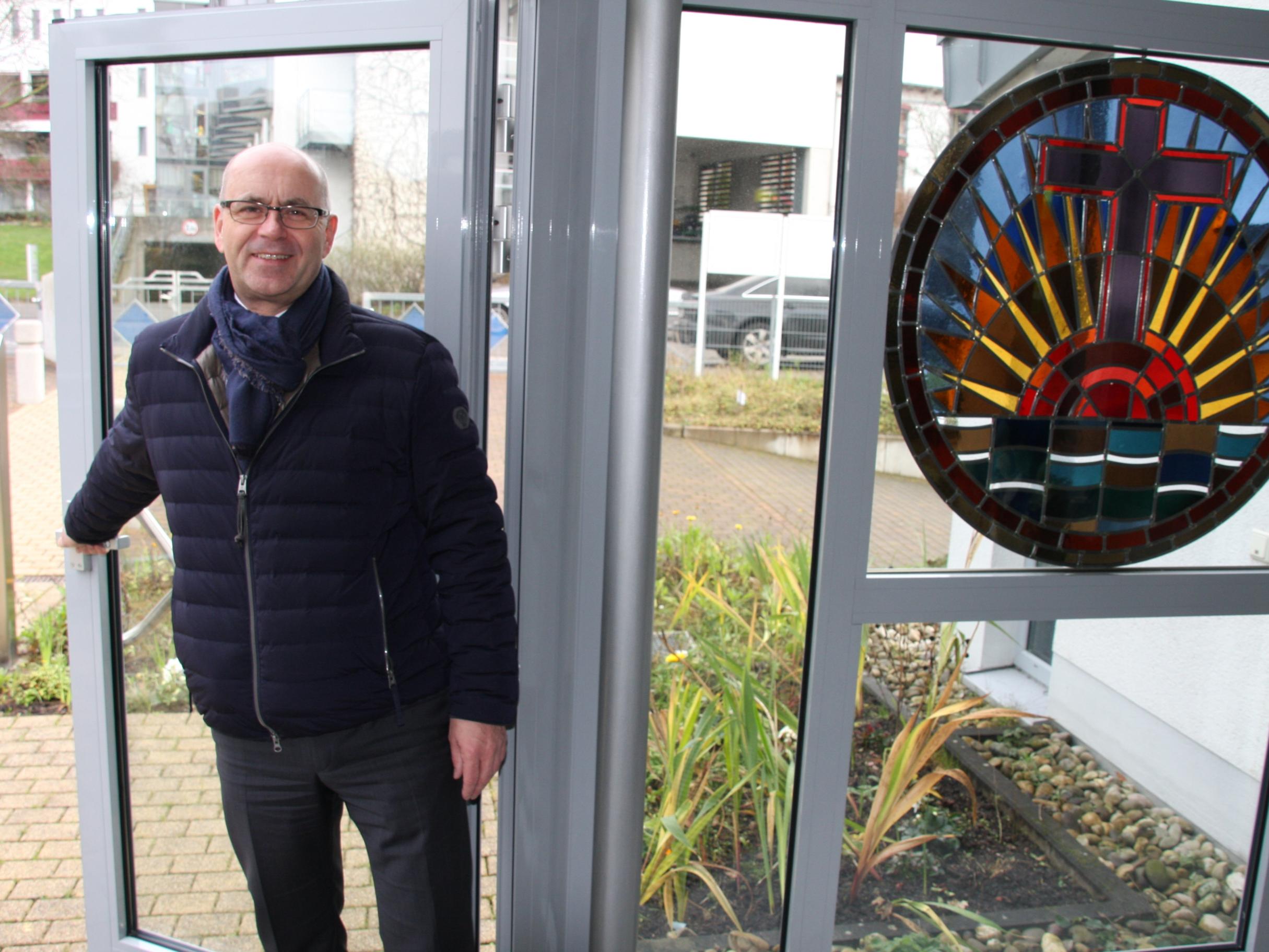 Gemeindeleiter Roger Tech von der Neuapostolischen Kirche, Gemeinde Koblenz, öffnet die Tür für interessierte Gottesdienstbesucher