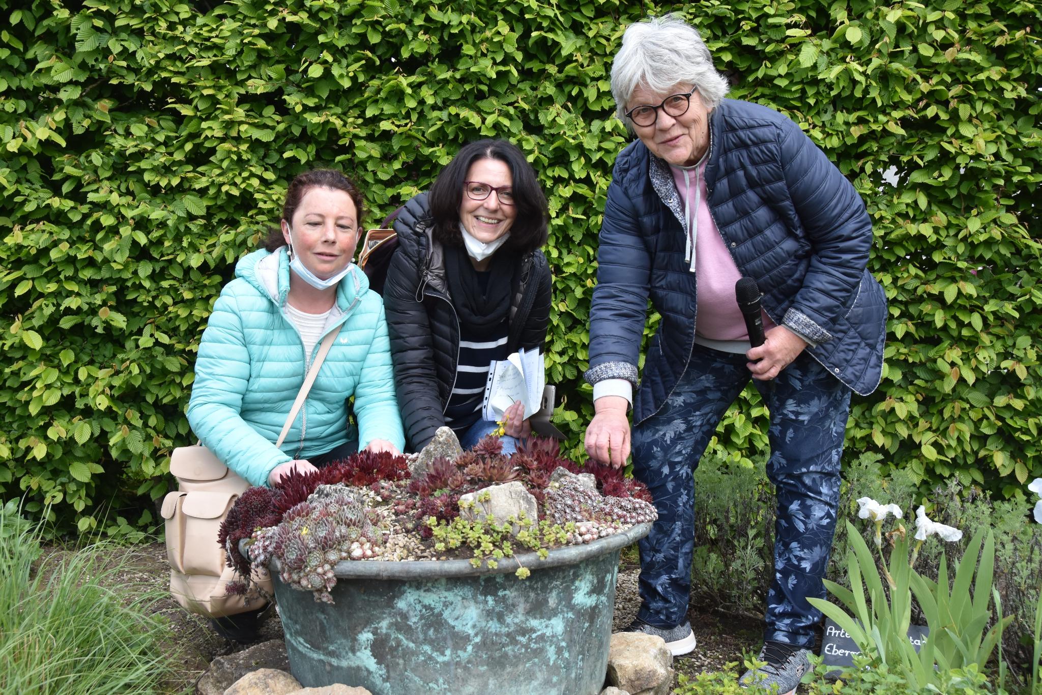 Nicole Hemmerling, Hiltrud Scherer (Begleitperson) und Ulrike Heffinger, Leiterin des Projektbüros Gärten ohne Grenzen, vor einem Pflanzenkübel mit Sedum. Foto: Ute Kirch/Bischöfliche Pressestelle