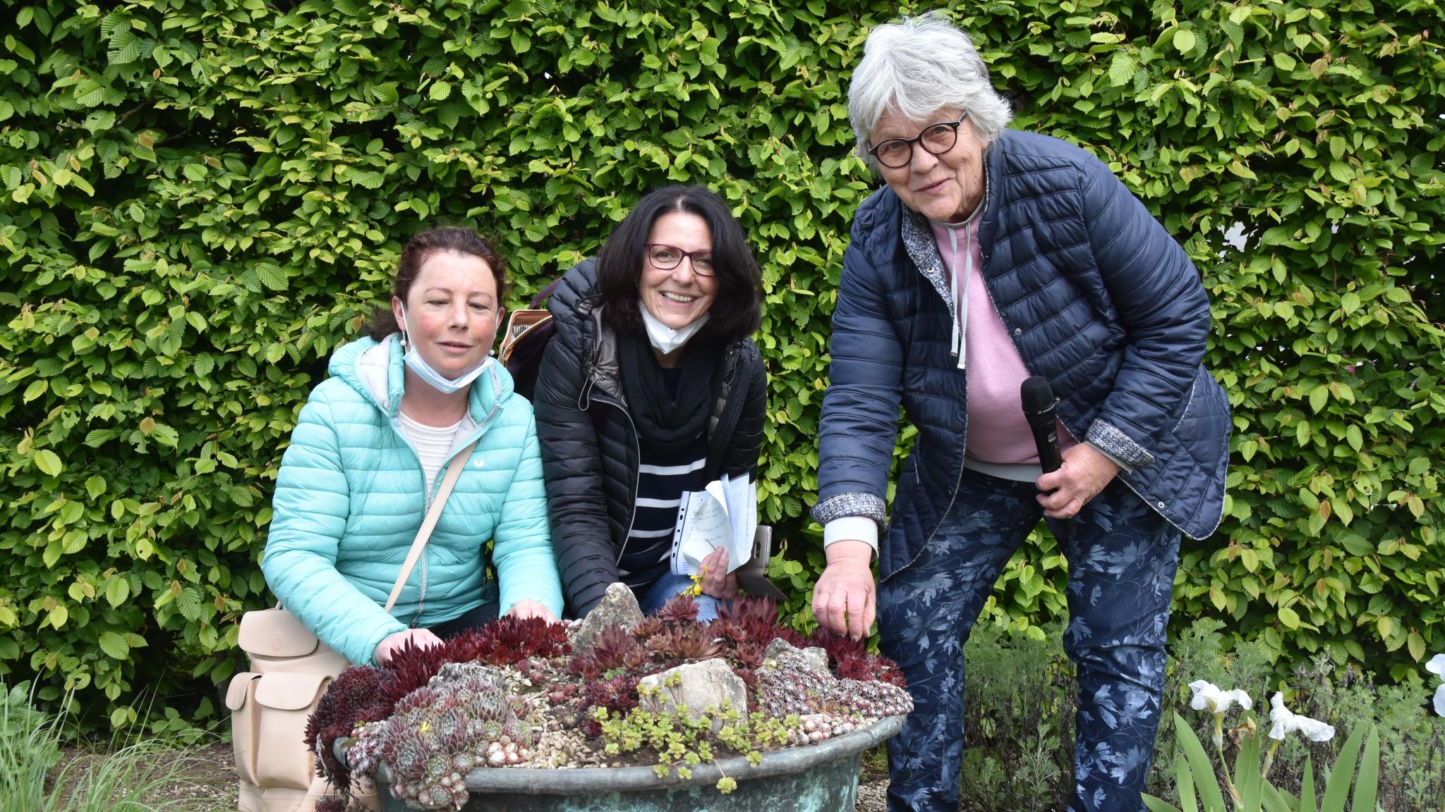 Nicole Hemmerling, Hiltrud Scherer (Begleitperson) und Ulrike Heffinger, Leiterin des Projektbüros Gärten ohne Grenzen, vor einem Pflanzenkübel mit Sedum. Foto: Ute Kirch/Bischöfliche Pressestelle