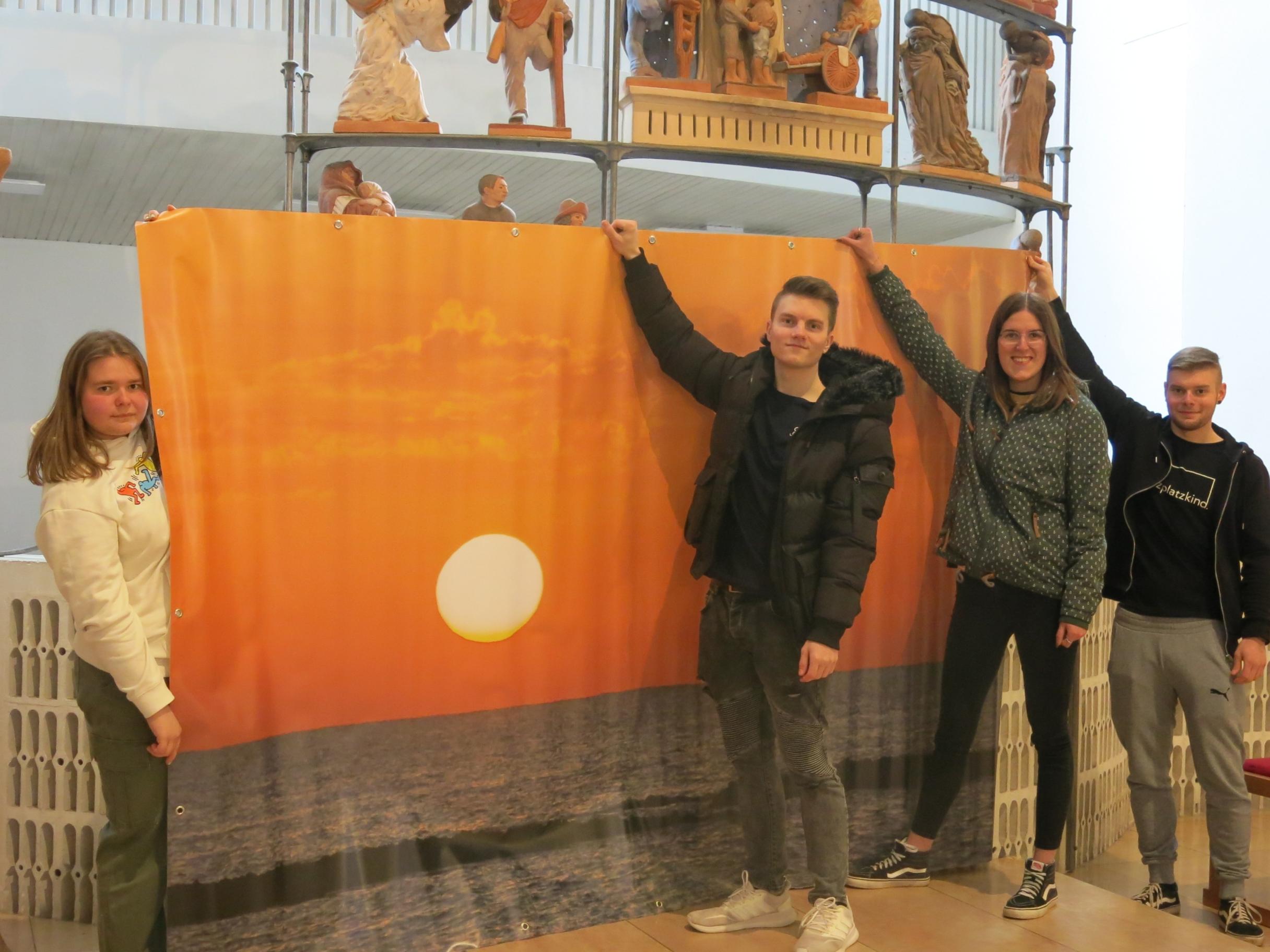 Bringen Plakatmotiv zentral im Altarbereich an, damit es von überall einsehbar ist: Chantal Schwinn, Tim Lessel, Franziska Dengler und Adrian Schwinn. Foto: Klaus Friedrich