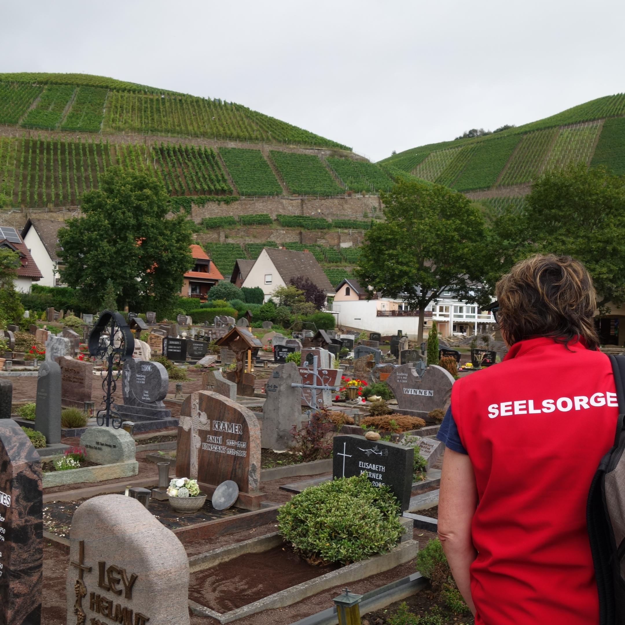 Das Koordinierungsbüro 'Seelsorge Ahr' des Bistums Trier plant Einsätze von Seelsorgerinnen und Seelsorgern. Hier zu sehen Esther Braun-Kinnen im August auf dem Friedhof in Dernau, wo Anwohnerinnen und Anwohner die Gräber ihrer Angehörigen aufsuchen. Foto: Julia Fröder/Bistum Trier