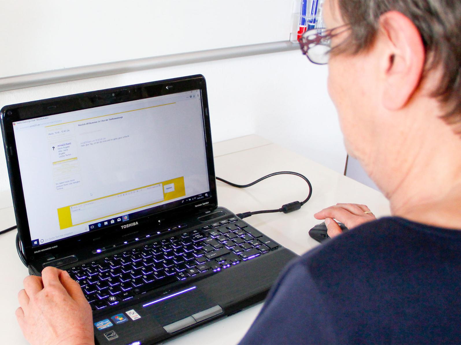 Digitalisierte Seelsorge: Eine der Ehrenamtlichen vor dem geöffneten Chatfenster der Telefonseelsorge.