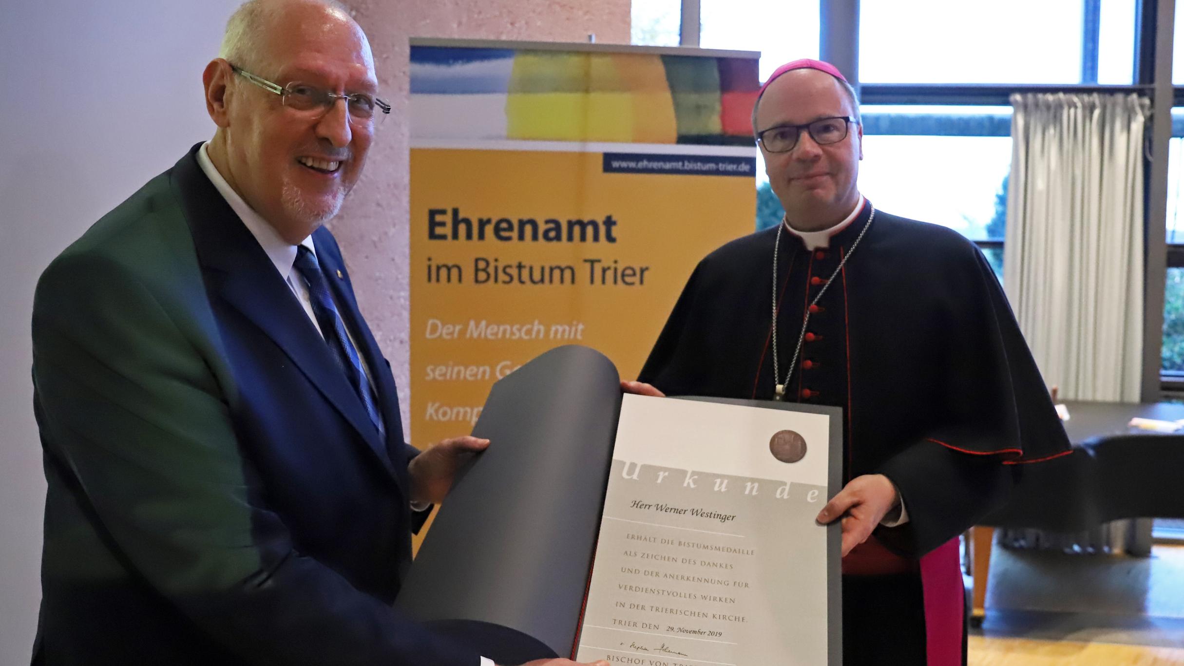 Bischof Ackermann überreicht Werner Westinger (links) aus Weißenthurm die Bistumsmedaille.