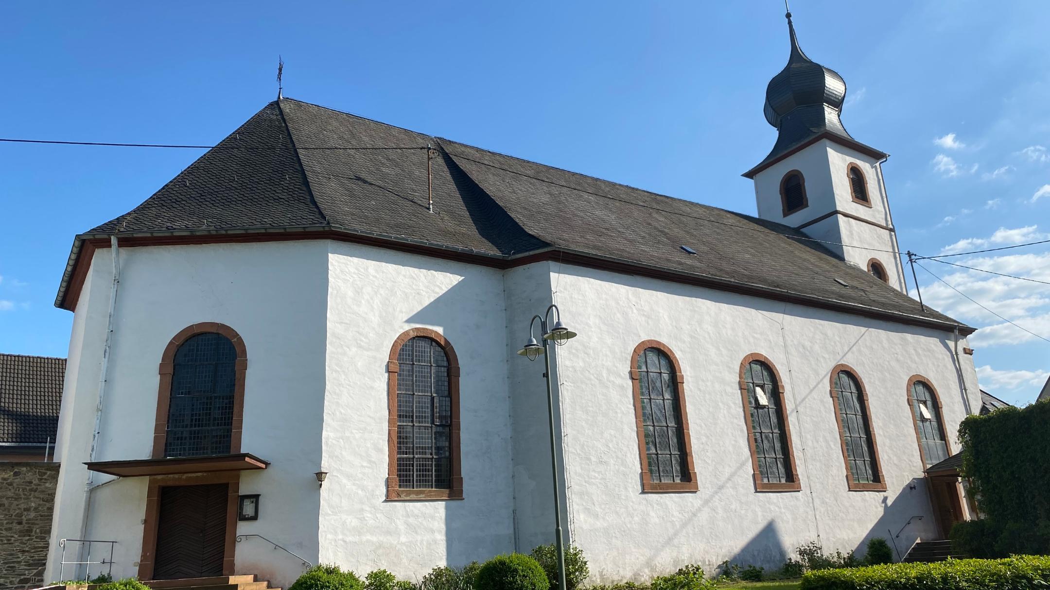 Brauneberg St. Remigius 01 - Die Simultankirche von der Moselseite aus gesehen. Links am Chorbau der Eingang in den evangelischen Kirchenraum, rechts am turmseitigen Ende des Schiffs der Eingang in den katholischen Teil.