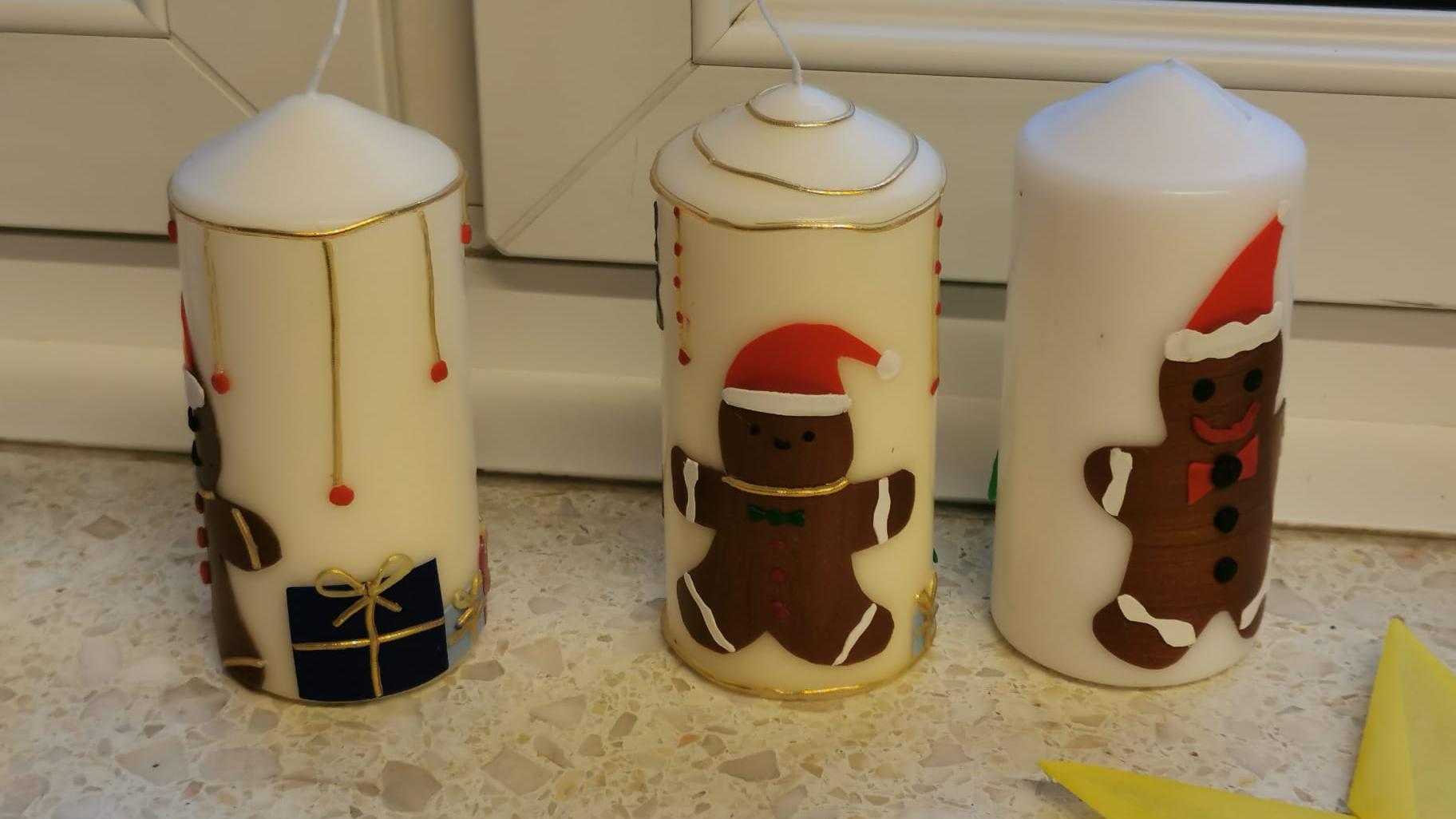 drei gebastelte Kerzen stehen auf dem Fensterbrett