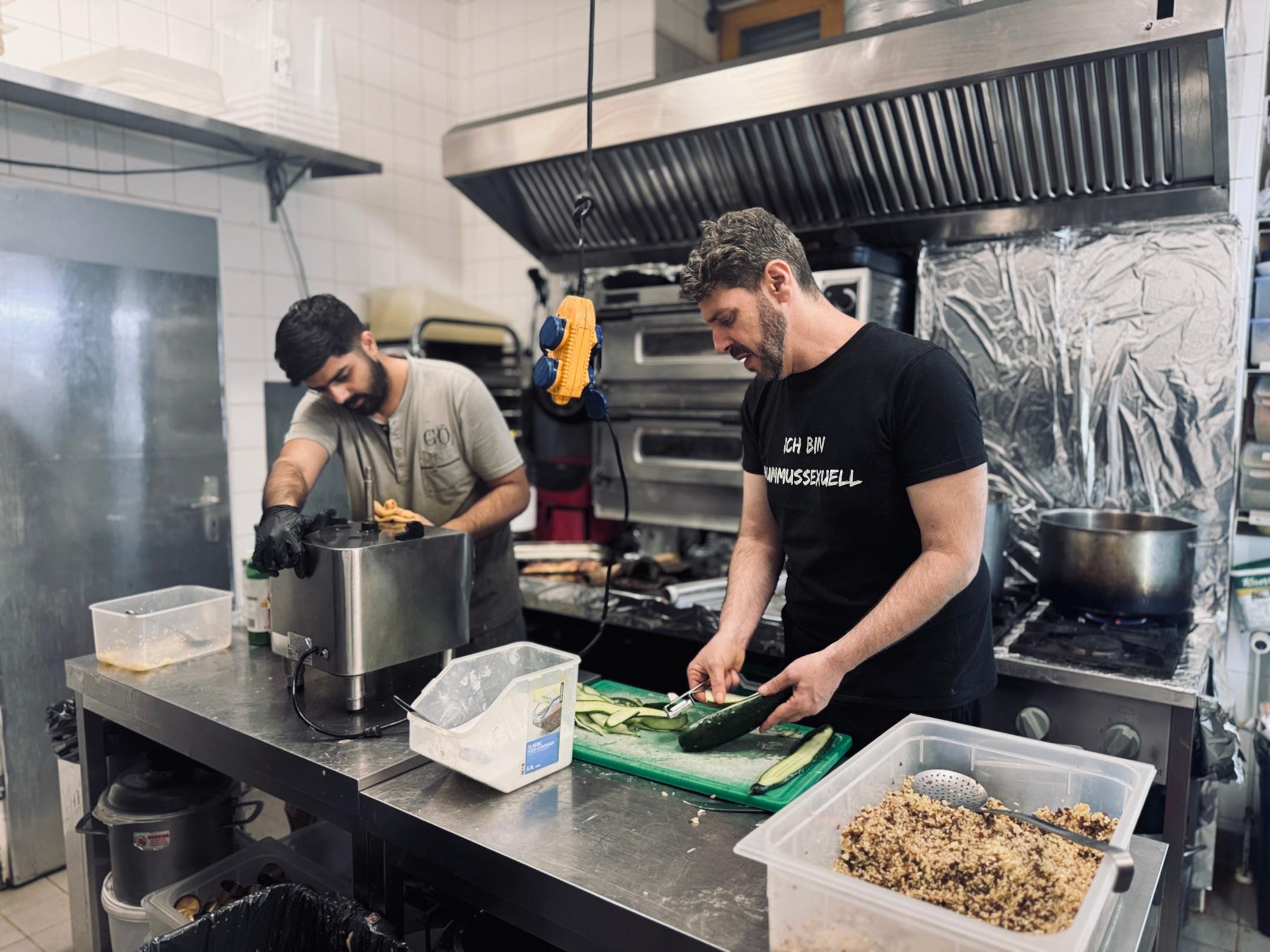 Zwei Köche arbeiten miteinander in einer Gastroküche