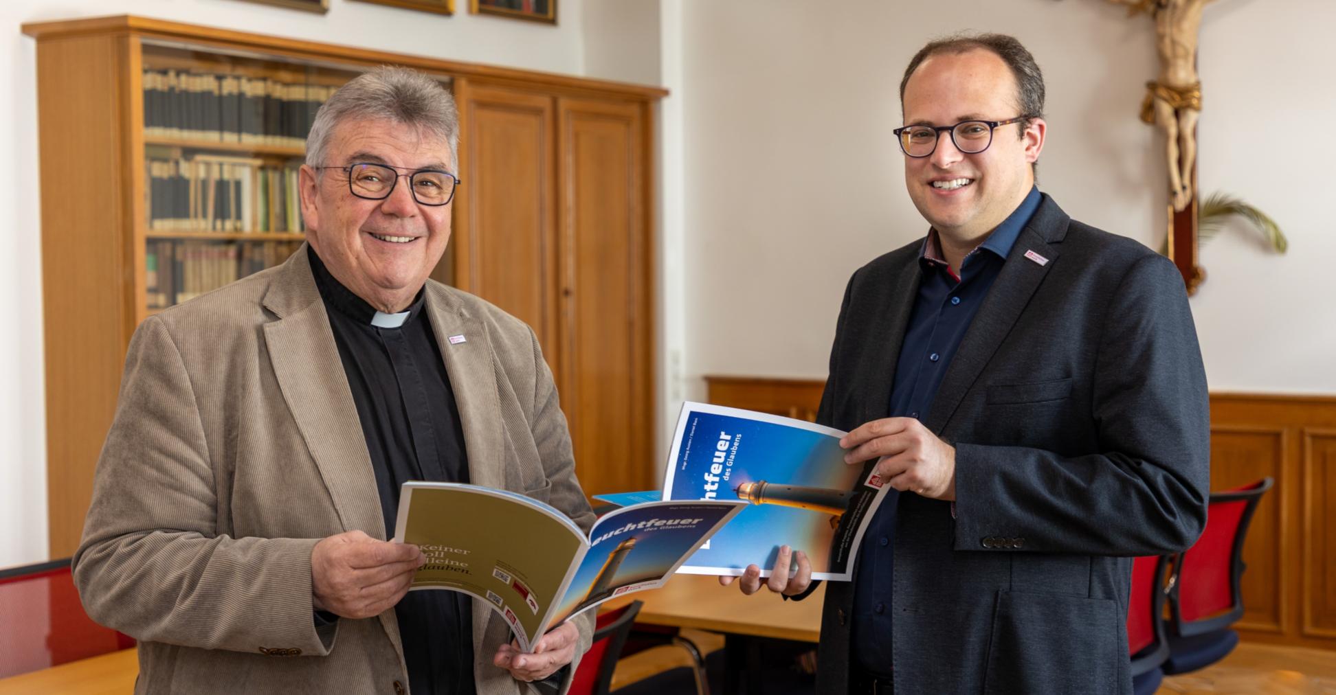 Die Autoren : der Generalsekretär des Bonifatiuswerks, Monsignore Austen (links), und Daniel Born, Referent im Bereich „Missionarische und diakonische Pastoral“ blättern in  der neuen Broschüre „Leuchtfeuer des Glaubens“.