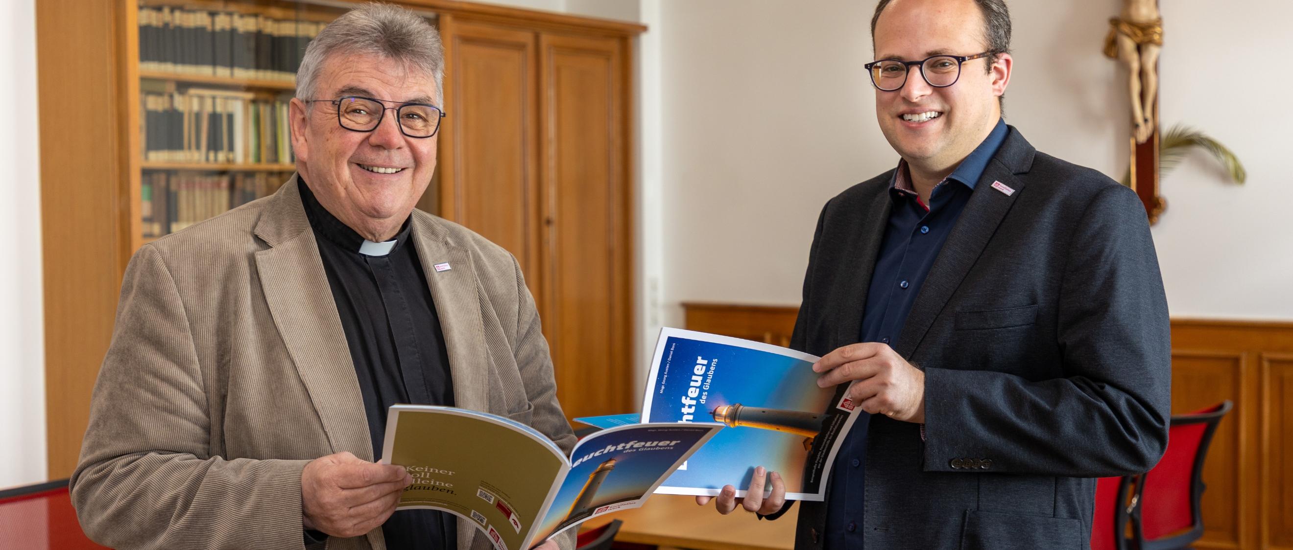 Die Autoren : der Generalsekretär des Bonifatiuswerks, Monsignore Austen (links), und Daniel Born, Referent im Bereich „Missionarische und diakonische Pastoral“ blättern in  der neuen Broschüre „Leuchtfeuer des Glaubens“.
