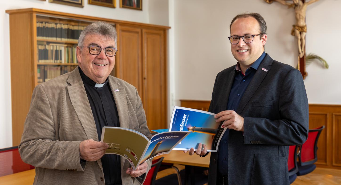 Die Autoren : der Generalsekretär des Bonifatiuswerks, Monsignore Austen (links), und Daniel Born, Referent im Bereich „Missionarische und diakonische Pastoral“ blättern in  der neuen Broschüre „Leuchtfeuer des Glaubens“.