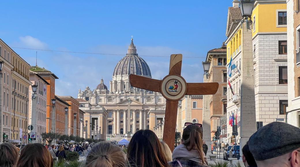 Eine deutsche Gruppe ist mit Pilgerkreuz unterwegs auf der Via della Conciliazione in Rom zum Petersdom.