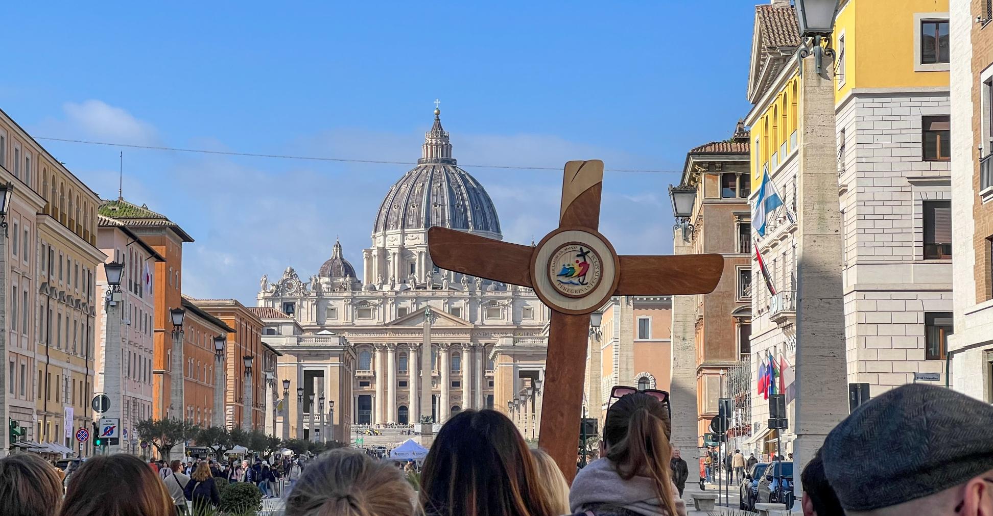 Eine deutsche Gruppe ist mit Pilgerkreuz unterwegs auf der Via della Conciliazione in Rom zum Petersdom.