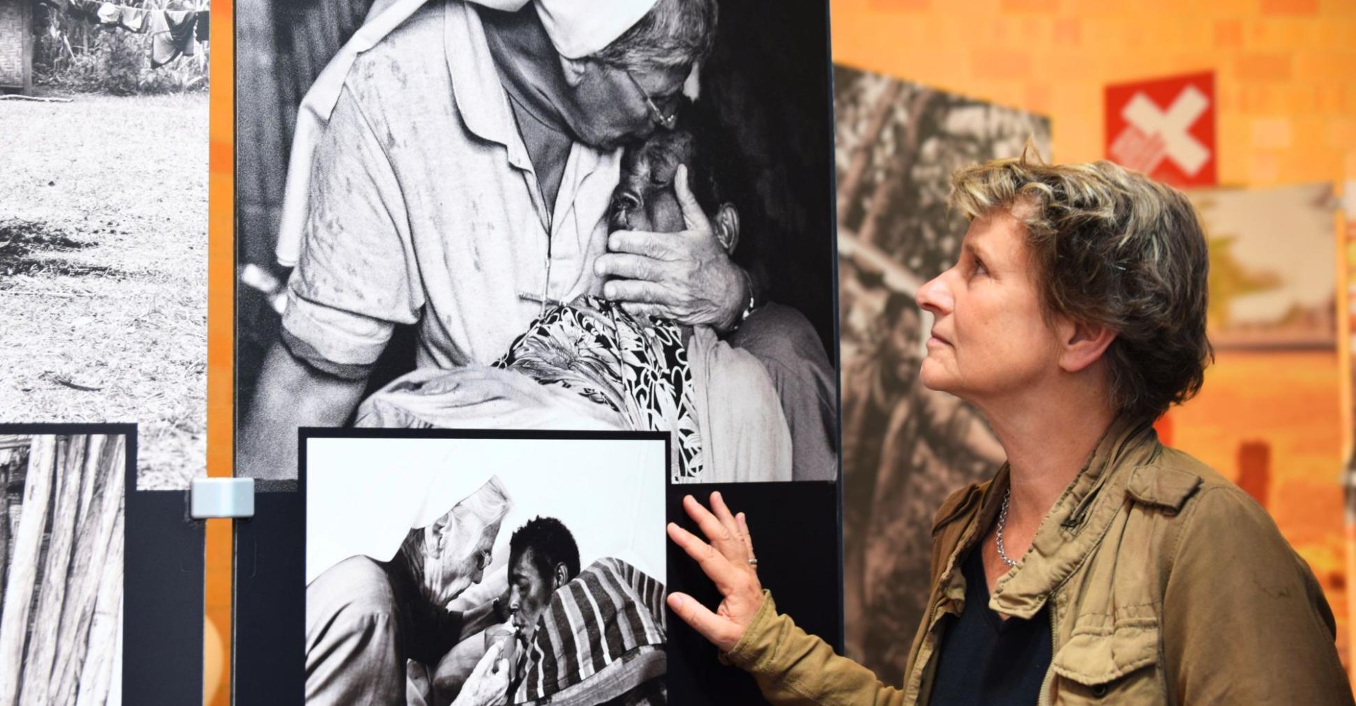 Eine Frau betrachtet schwarz-weiß-Fotografien auf großen Leinwänden