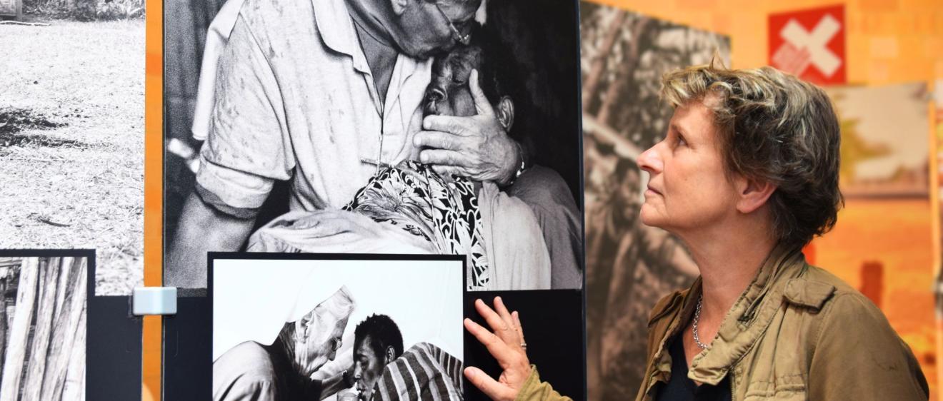Eine Frau betrachtet schwarz-weiß-Fotografien auf großen Leinwänden