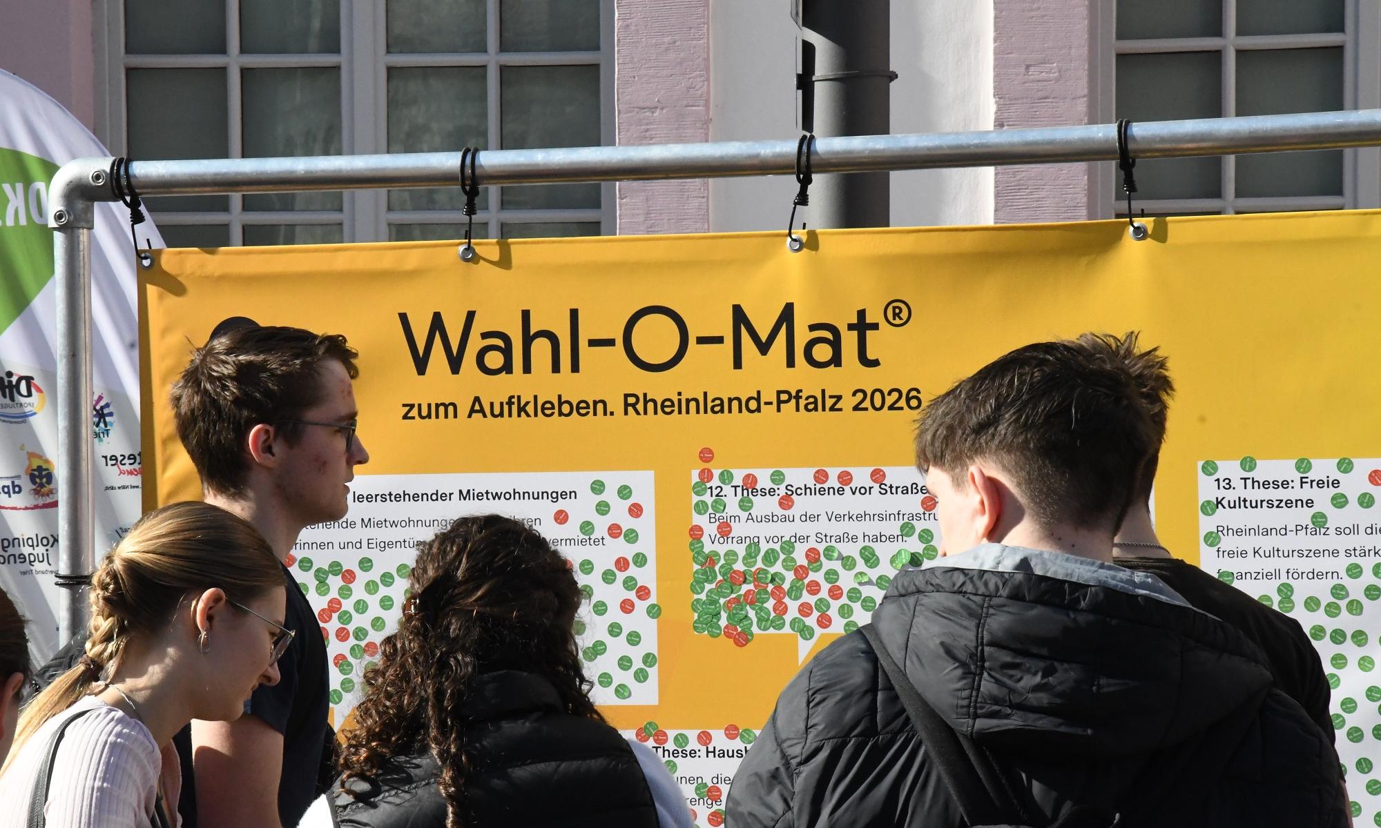 Jugendliche vor dem Wahl-O-Mat-Plakat.