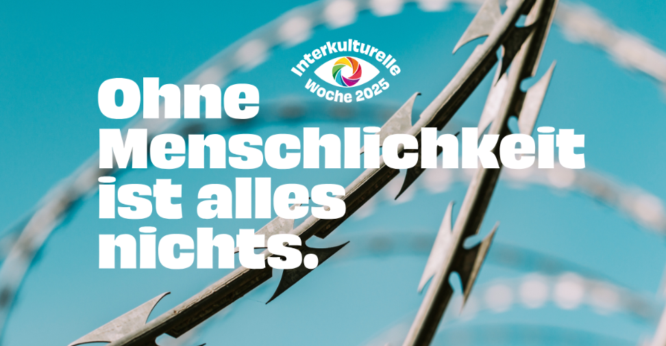 Im Hintergrund ist ein Stacheldrahtzaun zu sehen, im Vordergrund steht: 'Ohne Menschlichkeit ist alles nichts.'