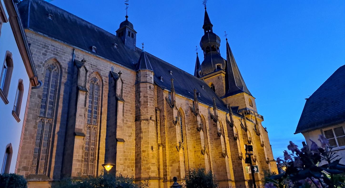 Große beleuchtete Kirche in der Abenddämmerung vor blauem Himmel