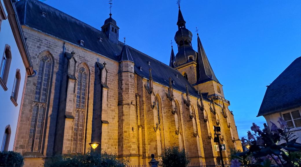 Große beleuchtete Kirche in der Abenddämmerung vor blauem Himmel