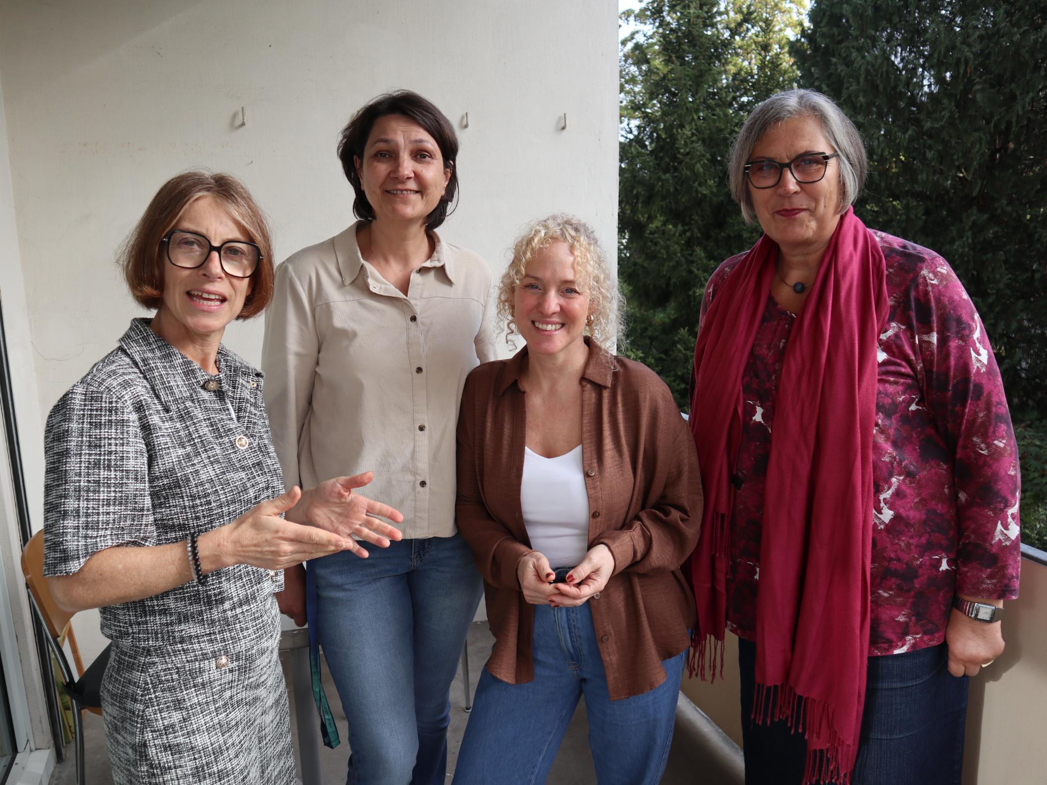 Vier Frauen unterschiedlichen Alters blicken freundlich in die Kamera