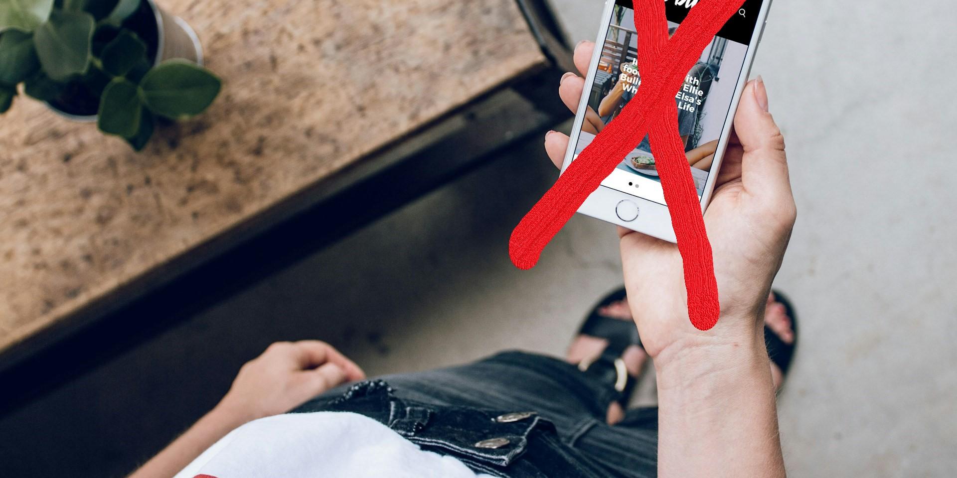 Man sieht von oben eine Hand, die ein Handy festhält, dieses ist mit einem großen roten X durchgestrichen.