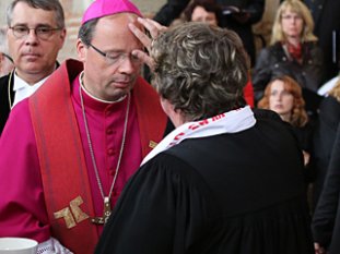 Tauferneuerung im ökumenischen Wallfahrts-Gottesdienst: Bischof Stephan Ackermann empfängt das Tauferinnerungszeichen von Oberkirchenrätin Barbara Rudolf