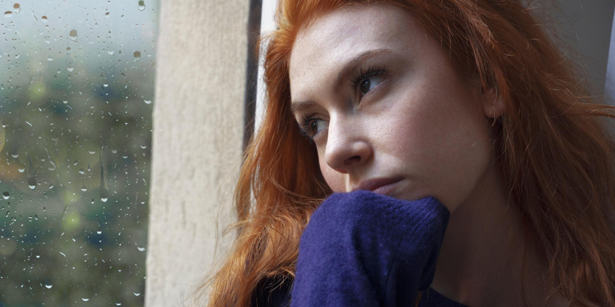 Frau am Fenster, nachdenklicher Blick