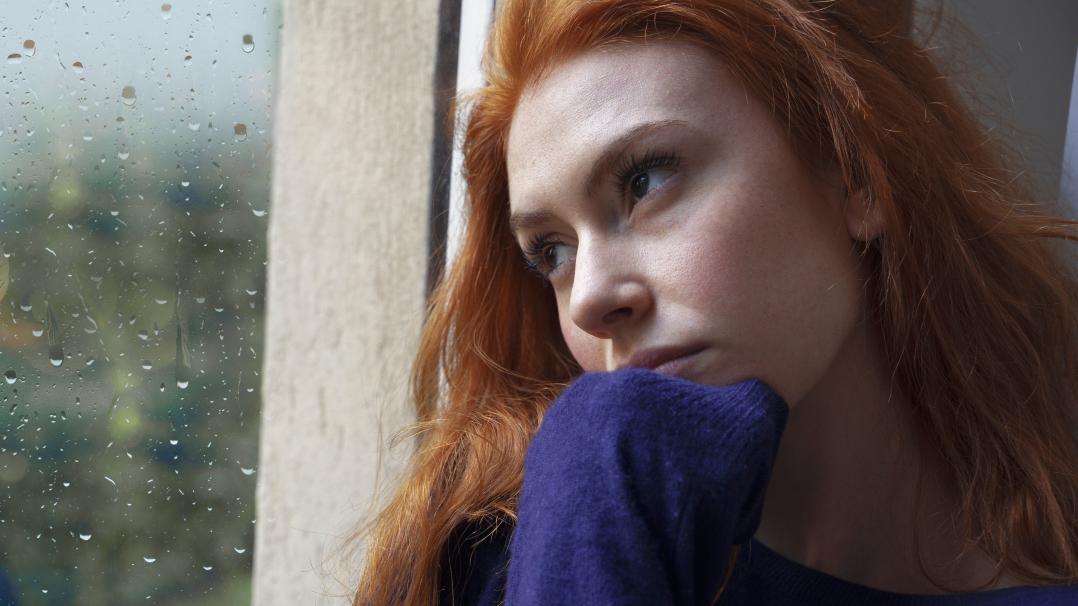 Frau am Fenster, nachdenklicher Blick