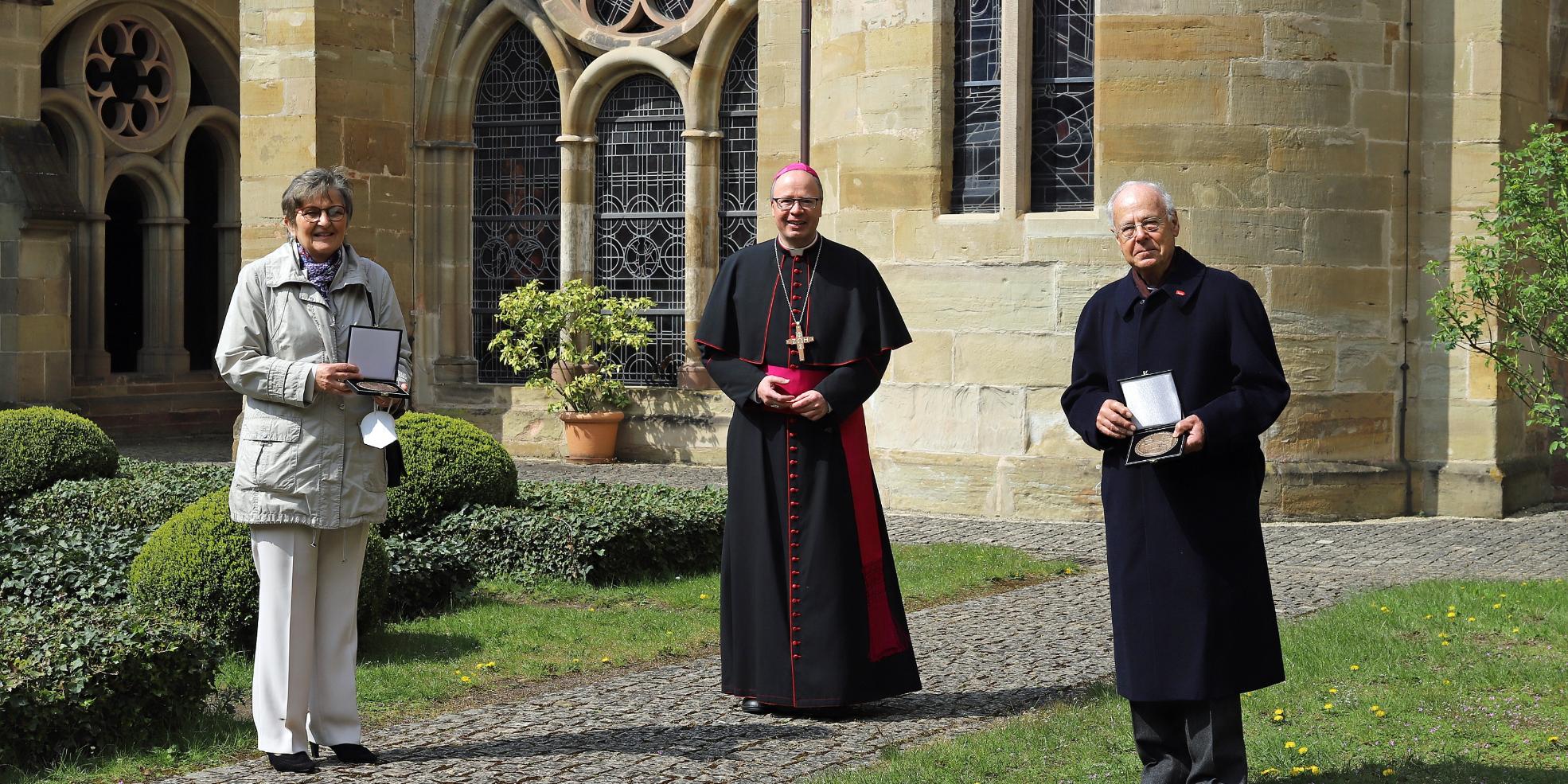 Bischof Ackermann mit Beate Born und Hans-Georg Reuter nach der Verleihung der Bistumsmedaille im Kreuzgang des Hohen Doms.