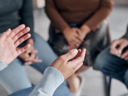 Gruppe die im Kreis sitzt und diskutiert