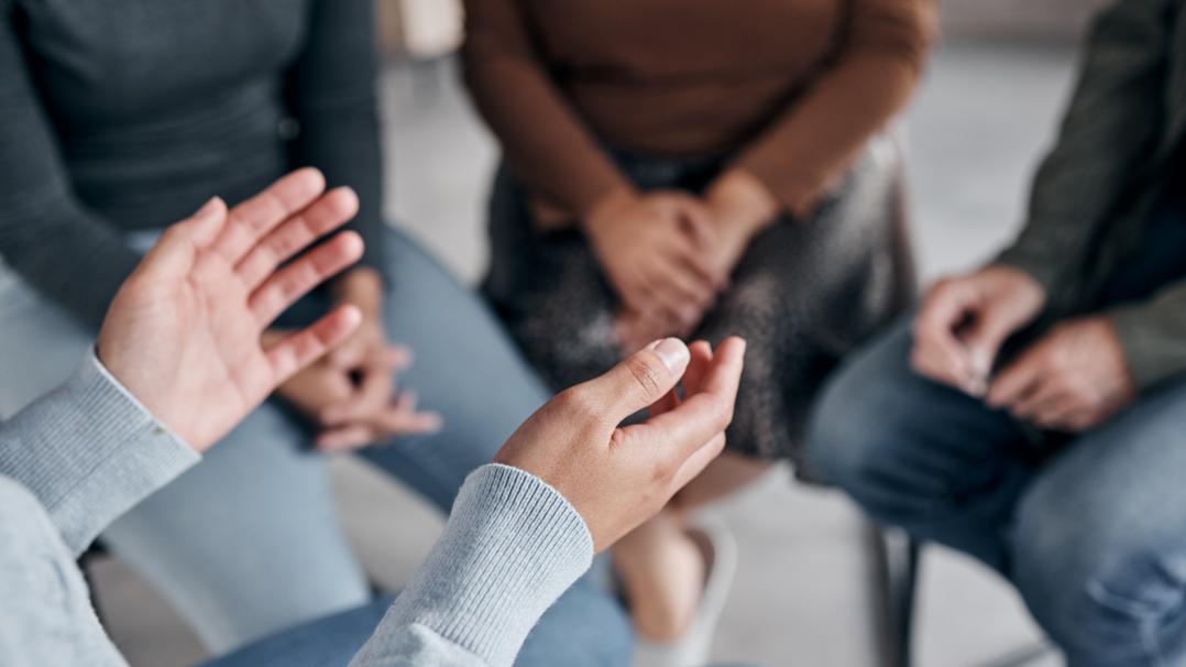 Gruppe die im Kreis sitzt und diskutiert