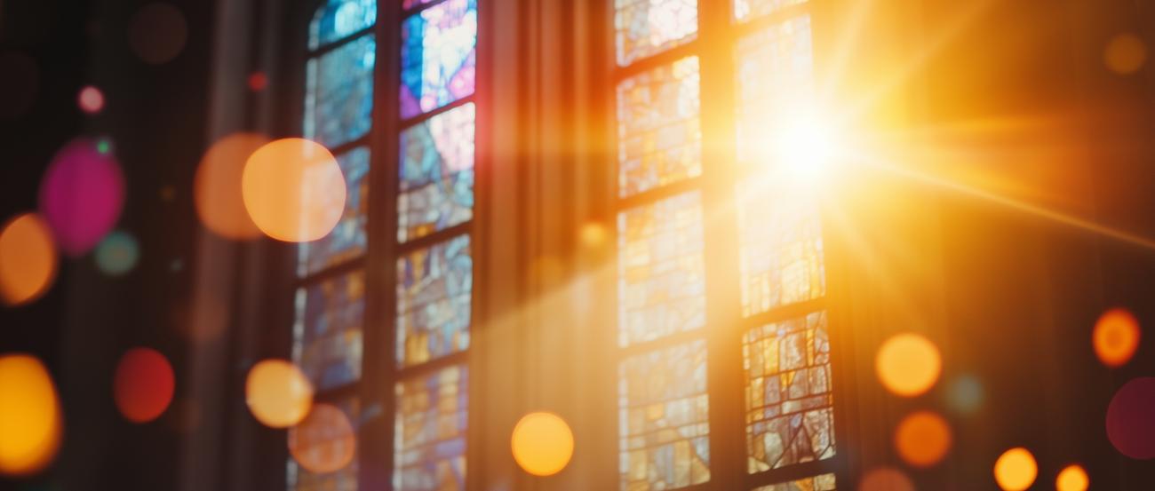 Kirchenfenster mit orangen Lichtreflexen