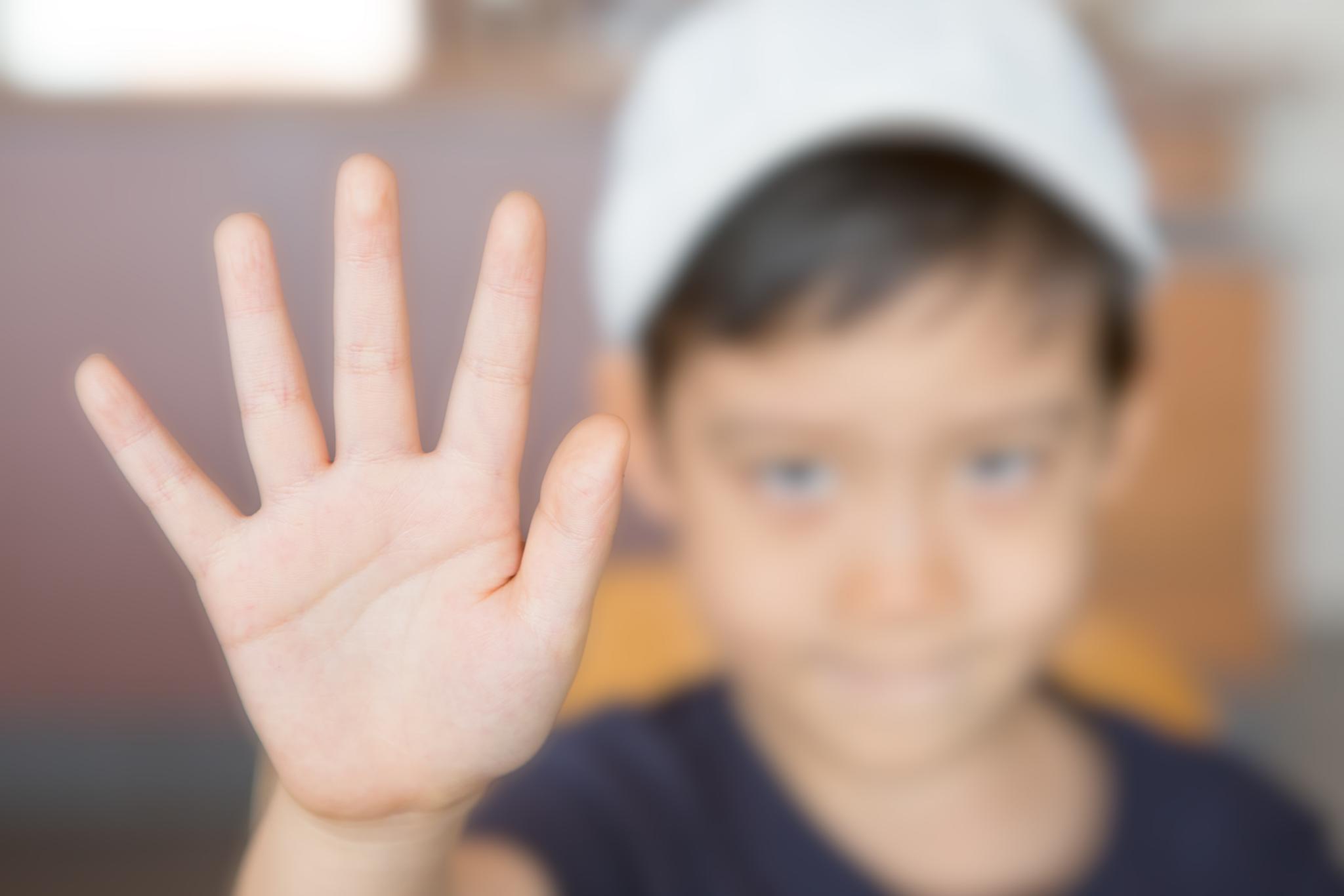 kleiner Junge der die Hand hebt